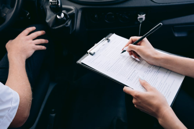 Car interior with passenger writing on a piece of paper attached to a clipboard